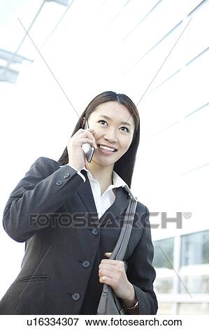 Stock Photo - Businesswoman Walking and Talking On Phone. Fotosearch
