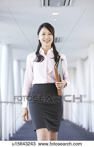 Stock Image - Businesswoman Walking in Corridor. Fotosearch