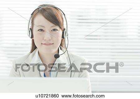 Stock Image - Businesswoman with Laptop Using Headset. Fotosearch