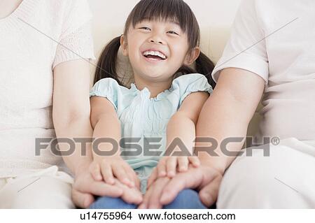 Picture - Daughter Sitting In Between Grandparents. Fotosearch