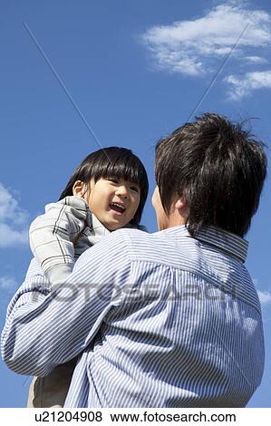 Stock Photo - Father and Boy Against Blue Sky. Fotosearch