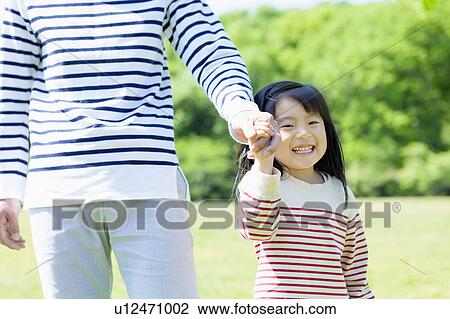 Stock Image - Father and daughter holding hands. Fotosearch