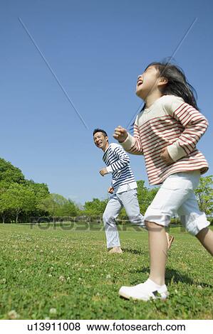 Father and daughter running in park View Large Photo Image Stock Photo - Father and daughter running in park. Fotosearch