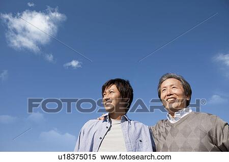 Stock Photography - Father and Son Against Blue Sky. Fotosearch