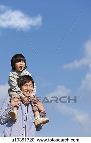 Stock Image - Father Carrying Boy on Shoulders. Fotosearch