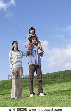 Stock Photo - Father Carrying Son on Shoulders, Mother Beside. Fotosearch