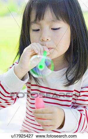 Girl blowing bubbles View Large Photo Image Stock Photo - Girl blowing bubbles. Fotosearch