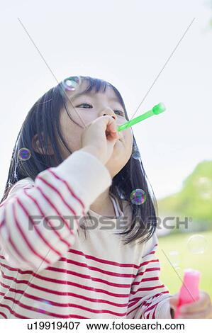 Stock Photo - Girl blowing bubbles. Fotosearch