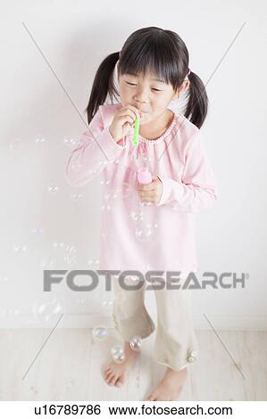 Stock Photograph - Girl Blowing Bubbles. Fotosearch