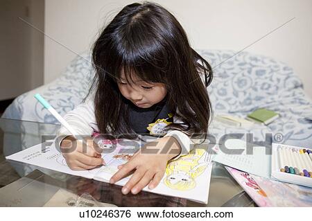 Stock Photograph - Girl coloring in book. Fotosearch