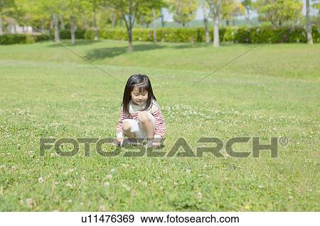 Girl crouching at park View Large Photo Image Stock Photo - Girl crouching at park. Fotosearch