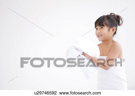 Girl holding a towel and smiling View Large Photo Image Stock Image - Girl holding a towel and smiling. Fotosearch