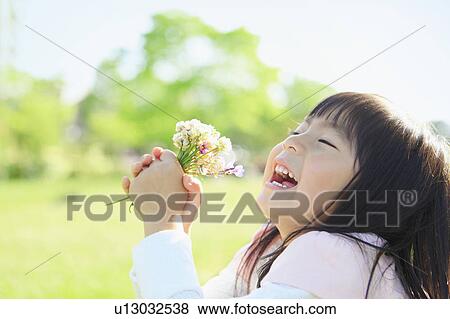 Girl holding wildflowers View Large Photo Image Stock Photo - Girl holding wildflowers. Fotosearch