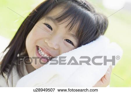 Girl hugging a towel View Large Photo Image Stock Photo - Girl hugging a towel. Fotosearch
