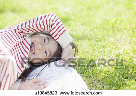Girl lying down on picnic blanket View Large Photo Image Stock Image - Girl lying down on picnic blanket. Fotosearch