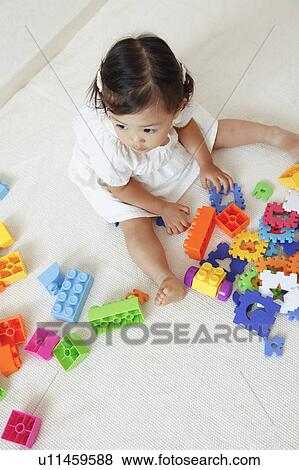 Girl playing with plastic blocks View Large Photo Image Stock Photo - Girl playing with plastic blocks. Fotosearch