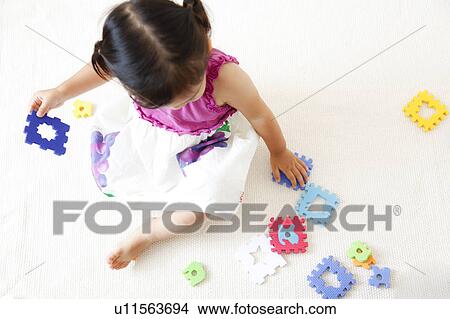 Picture - Girl playing with puzzle. Fotosearch