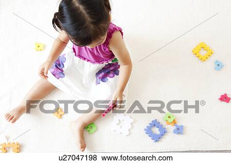 Stock Photo - Girl playing with puzzle. Fotosearch