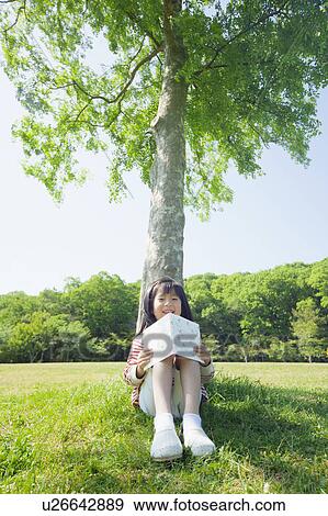 Girl reading a book View Large Photo Image Stock Photo - Girl reading a book. Fotosearch
