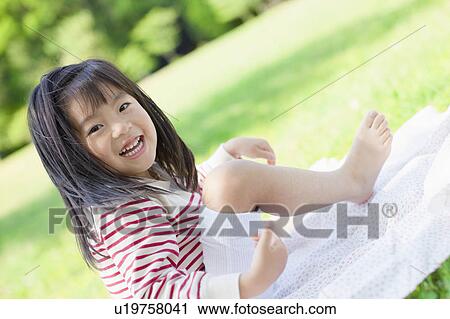 Girl sitting on picnic blanket View Large Photo Image Stock Image - Girl sitting on picnic blanket. Fotosearch