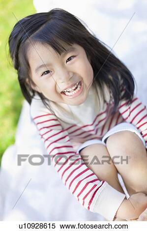 Stock Photography - Girl sitting on picnic blanket. Fotosearch