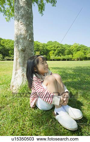 Girl sitting under a tree View Large Photo Image Stock Image - Girl sitting under a tree. Fotosearch