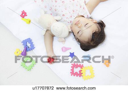 Stock Image - Girl sleeping with stuffed animal. Fotosearch