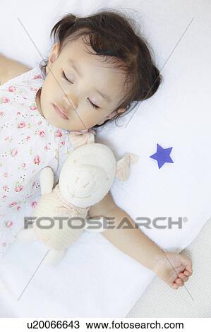 Stock Image - Girl sleeping with stuffed animal. Fotosearch