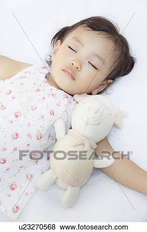 Stock Photo - Girl sleeping with stuffed animal. Fotosearch