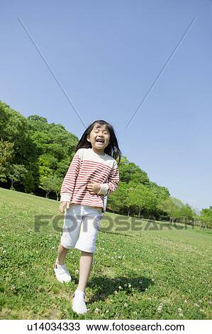 Girl standing and smiling at a park View Large Photo Image Stock Image - Girl standing and smiling at a park. Fotosearch