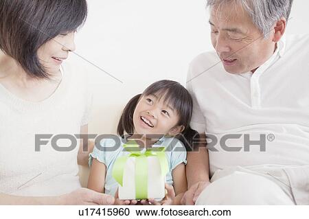 Grandparents Giving Granddaughter A Gift View Large Photo Image Stock Image - Grandparents Giving Granddaughter A Gift. Fotosearch