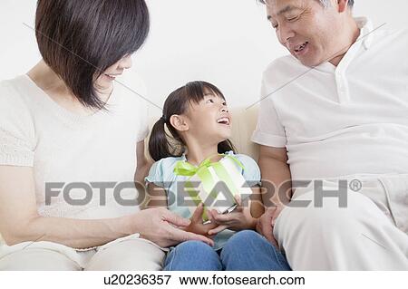Grandparents Giving Granddaughter A Gift View Large Photo Image Stock Photo - Grandparents Giving Granddaughter A Gift. Fotosearch