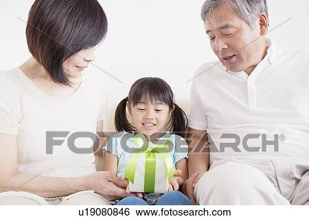 Stock Photograph - Grandparents Giving Granddaughter A Gift. Fotosearch