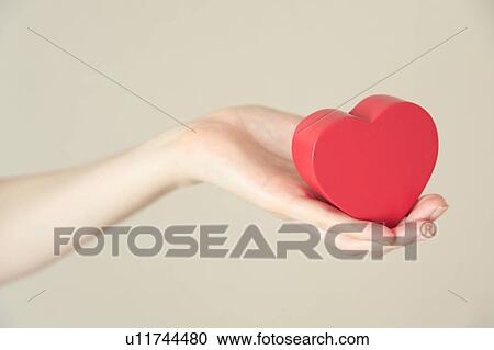 Heart shaped toy in hand View Large Photo Image Stock Image - Heart shaped toy in hand. Fotosearch