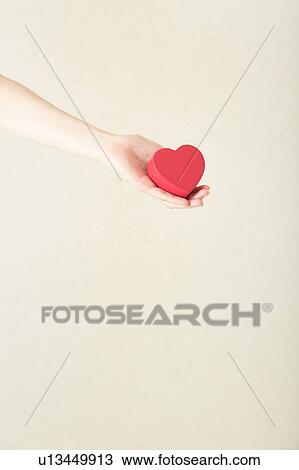 Stock Image - Heart shaped toy in hand. Fotosearch
