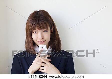 High School Student Listening Music With Mobile Phone and Smiling View Large Photo Image Picture - High School Student Listening Music With Mobile Phone and Smiling. Fotosearch