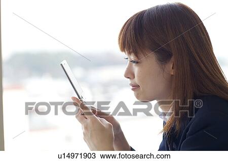 Stock Image - High School Student Looking at Mobile Phone. Fotosearch