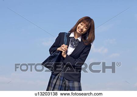 Stock Photo - High School Student Standing Against Sky. Fotosearch