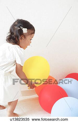 Stock Photography - Japanese Baby Girl Playing with Balloons. Fotosearch