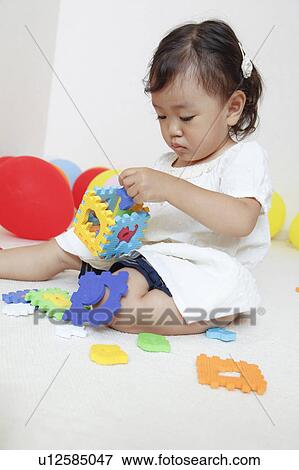 Stock Photo - Japanese Baby Girl Playing with Toys. Fotosearch