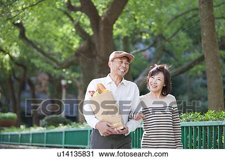 Stock Image - Mature couple after grocery shopping. Fotosearch