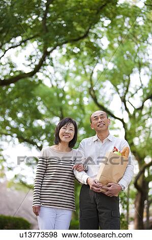 Stock Photo - Mature couple after grocery shopping. Fotosearch