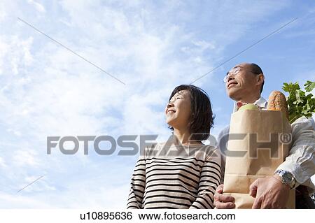 Stock Photograph - Mature couple after grocery shopping. Fotosearch
