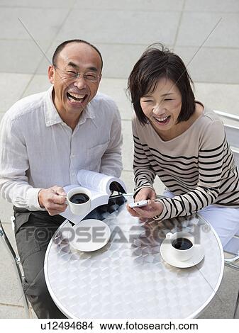 Picture - Mature couple having coffee outdoors. Fotosearch