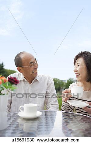 Mature couple having tea outdoors View Large Photo Image Stock Image - Mature couple having tea outdoors. Fotosearch