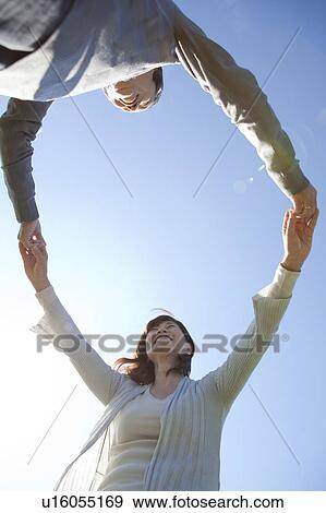 Stock Photo - Mature Couple Holding Hands, Low Angle View. Fotosearch