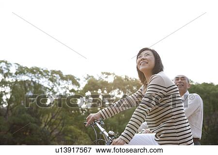 Mature couple on bicycle looking up View Large Photo Image Stock Photo - Mature couple on bicycle looking up. Fotosearch