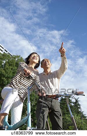Mature couple on bicycle looking up View Large Photo Image Stock Photo - Mature couple on bicycle looking up. Fotosearch