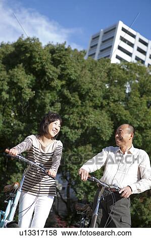 Mature couple pushing bicycles View Large Photo Image Stock Photo - Mature couple pushing bicycles. Fotosearch