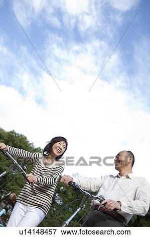 Mature couple pushing bicycles View Large Photo Image Stock Photo - Mature couple pushing bicycles. Fotosearch